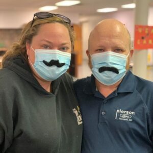 female and male having funwearing masks with mustache stickers