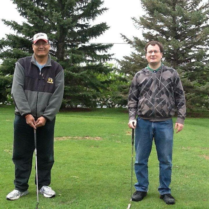 Aspire male clients smiling with golf clubs at golf tournament